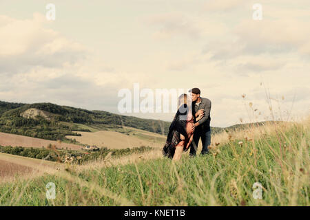 Romantische schwanger Mitte nach paar Küssen auf ländliche Hügel Stockfoto