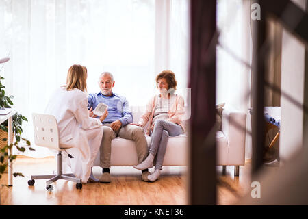 Ärztin Kontrolle Blutdruck von älteren Menschen. Stockfoto