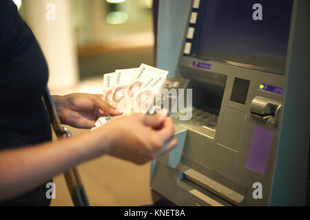 7/8-Ansicht von Frau Geld Abheben aus Geldautomaten Stockfoto