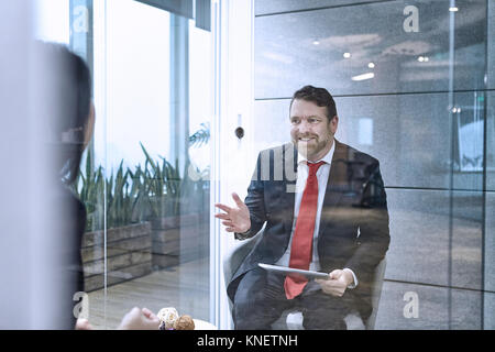 Blick durch die Glaswand der Kollegen in Treffen im Büro Stockfoto