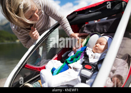 Ältere Frau und Enkel in jogging Stroller. Stockfoto