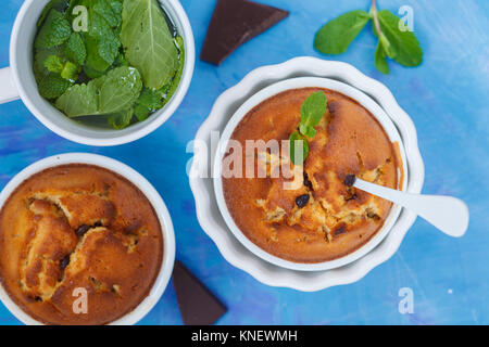 Schokolade cupkakes mit Pfefferminztee, blauer Hintergrund, Ansicht von oben. Süße hausgemachte Konzept. Stockfoto