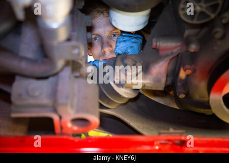 Ein Mechaniker Arbeiten am Motor mit einem Bus von unten. Stockfoto