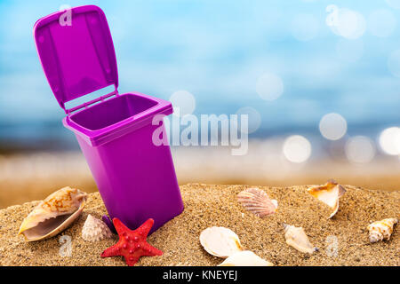 Mülleimer auf sauberen Sand und Muscheln mit seascape Hintergrund Stockfoto