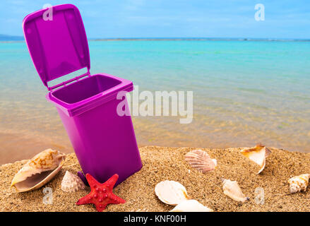 Mülleimer auf sauberen Sand und Muscheln mit seascape Hintergrund Stockfoto