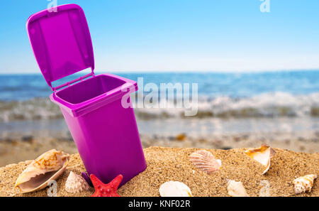 Mülleimer auf sauberen Sand und Muscheln mit seascape Hintergrund Stockfoto