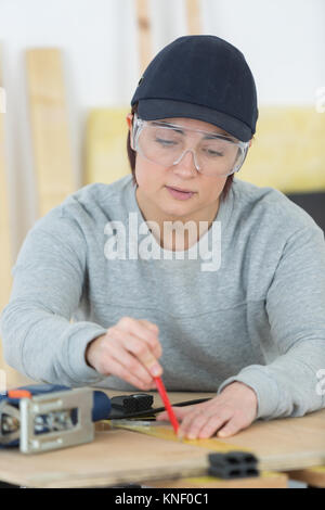 Porträt von glücklich weibliche Schreiner Ausarbeitung neues Projekt in Werkstatt Stockfoto