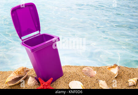Mülleimer auf sauberen Sand und Muscheln mit seascape Hintergrund Stockfoto