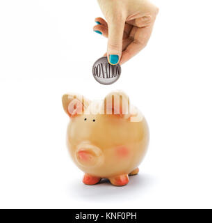 Hand Hinterlegung Münze mit Spende Text in piggy Bank Stockfoto