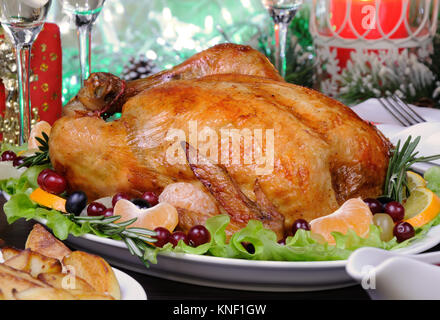 Zarte gebackenes Huhn mit eine appetitliche Kruste mit einem Citrus garnieren auf der Weihnachten Tabelle Stockfoto