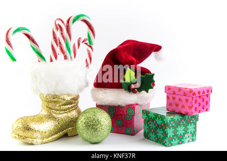 Santas Hut und Stiefel mit Geschenkboxen und Ornamente isoliert Stockfoto