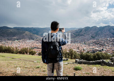 Mann fotografieren Blick von Sacsayhuaman, mit Smartphone, Cusco, Peru, Südamerika Stockfoto