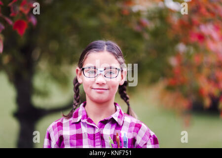Mädchen mit Zöpfen und zerbrochene Gläser, verkleidet als Nerd Stockfoto