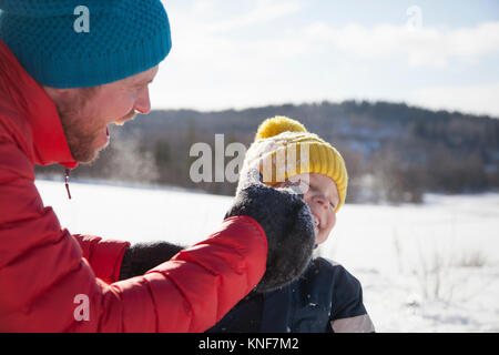 Mann und Sohn im Schnee lachen Landschaft Stockfoto