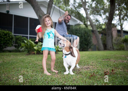 Vater und Tochter im Garten mit Hund Stockfoto