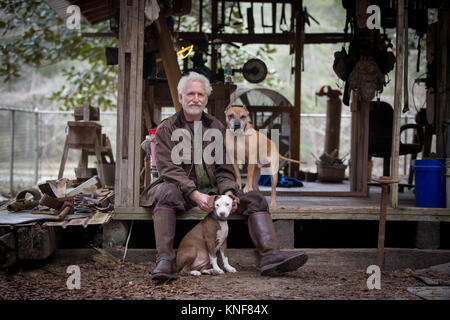 Mann mit Hunden durch hölzerne Arbeit Hütte Stockfoto