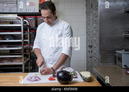 Koch in der gewerblichen Küche schneiden Aubergine Stockfoto