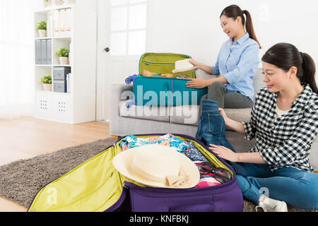 Gerne hübsche Schwestern Kleidung zu packen persönlichen Gepäck Koffer in Wohnzimmer und bereit, Familie reisen in den Sommerferien. Stockfoto