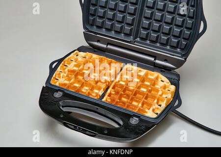 Zwei heiße Waffeln im Kochen Waffeln Teekocher bereit Stockfoto