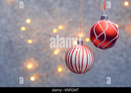 Bild von Weihnachten rote Kugeln mit Muster auf grauem Hintergrund mit brennenden Lichtern. Stockfoto