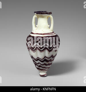 Dieser Amphoriskos ist ein altes Glasgefäß mit einem schlanken Körper und engem Hals, das historisch zur Lagerung von Parfüm oder Ölen verwendet wurde. Es ist ein Beispiel für klassisches Glashandwerk und Design aus der römischen und griechischen Antike. Stockfoto