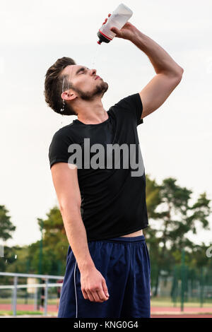 Mann Trinken von Wasser Flasche während Sport Stockfoto