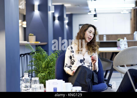 East Asian Business Executive in einer Konferenz in einem modernen Büro Stockfoto