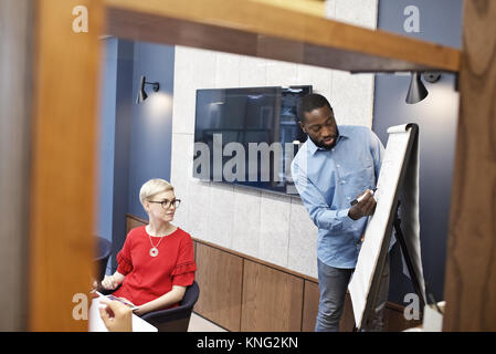 Schwarzer Geschäftsmann eine Business Präsentation zu einer Gruppe von Kollegen in einem modernen Büro Stockfoto