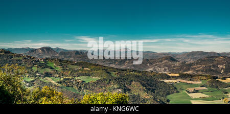 Felder und Wälder im nördlichen Apennin gemischt. Monte Cimone im Hintergrund. Stockfoto