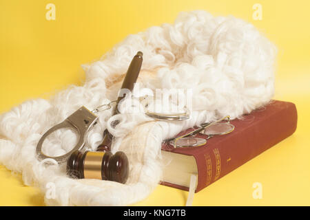 Für Richter: Richter Perücke, handclufs, Richter Hammer, Buch Ende Brillen auf gelbem Hintergrund Stockfoto