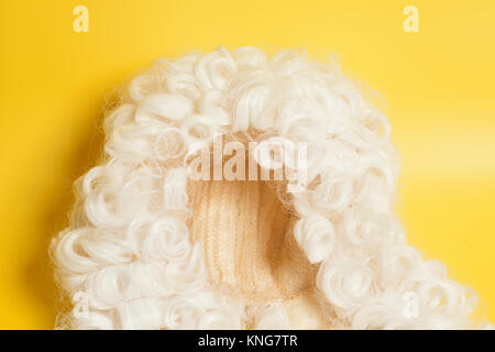 Perücke auf gelbem Hintergrund beurteilen. Stockfoto