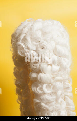 Perücke auf gelbem Hintergrund beurteilen. Stockfoto
