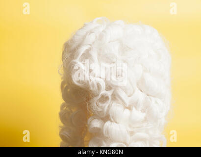 Perücke auf gelbem Hintergrund beurteilen. Stockfoto