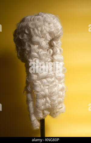 Perücke auf gelbem Hintergrund beurteilen. Stockfoto