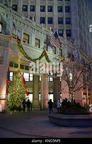 Feiertagkäufer auf der Michigan Avenue "tollem Meile zu Fuß vorbei an der Weihnachtsbeleuchtung auf dem Wrigley Gebäude auf einen lebhaften Abend in Chicago. Stockfoto