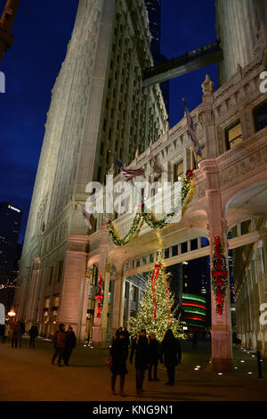 Feiertagkäufer auf der Michigan Avenue "tollem Meile zu Fuß vorbei an der Weihnachtsbeleuchtung auf dem Wrigley Gebäude auf einen lebhaften Abend in Chicago. Stockfoto