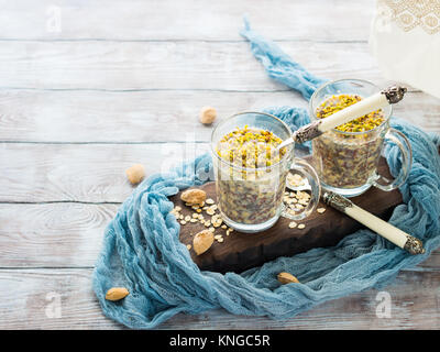 Chia gerollt oat Pudding über Nacht Porridge mit Quinoa, Banane, Pistazien, Milch. Eine Tasse gesundes Frühstück Stockfoto