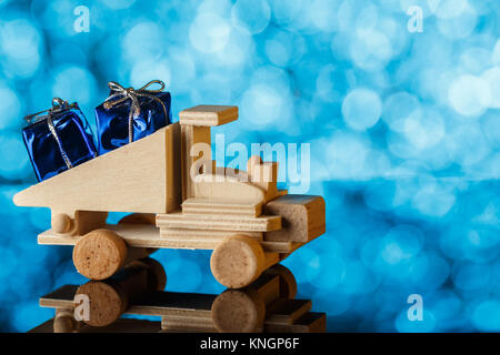 Lieferung der Geschenke. Spielzeug-LKW fährt ein kleines Geschenk. Urlaub Karte. Ein Platz für Glückwünsche. Stockfoto