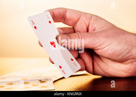Nahaufnahme einer Hand, die ein Herz Ass Spielkarten. Stockfoto