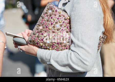 Mailand - 24. SEPTEMBER: Frau mit Tasche mit goldenen Nieten Dekoration und Perlen am Telefon vor Trussardi fashion show, Mailand Fashion Week Straße Stockfoto