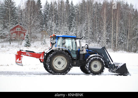 SALO, Finnland - 22. NOVEMBER 2014: Valtra Traktor entfernt Schnee mit Schaufel und VM Straße ziehen. In Finnland, Schnee Umzugskosten können erheblich sein. Stockfoto