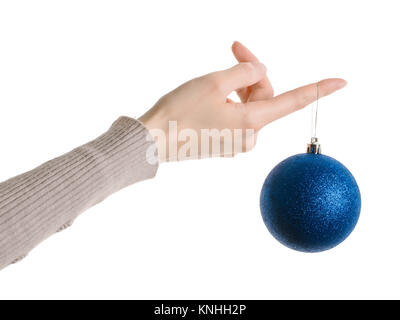 Frau Hand in Pullover Holding blue christmas Ball auf dem Finger. Auf weißen, Beschneidungspfade getrennt ausgewiesen Stockfoto