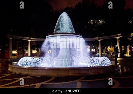 Der Brunnen im Zentrum der Stadt. Blick auf die überfüllten Straße und Menschen in Baku, Aserbaidschan. Night Vision eines runden Park Brunnen Stockfoto