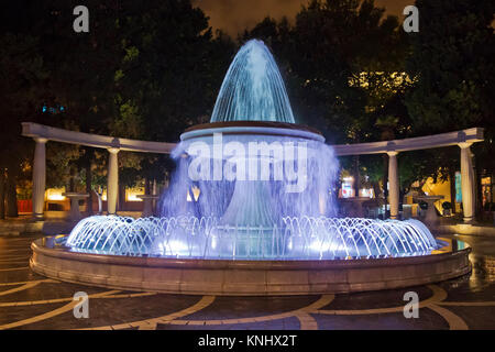 Der Brunnen im Zentrum der Stadt. Blick auf die überfüllten Straße und Menschen in Baku, Aserbaidschan. Night Vision eines runden Park Brunnen Quadrat Stockfoto