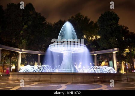 Der Brunnen im Zentrum der Stadt. Blick auf die überfüllten Straße und Menschen in Baku, Aserbaidschan. Night Vision eines runden Park Brunnen Stockfoto