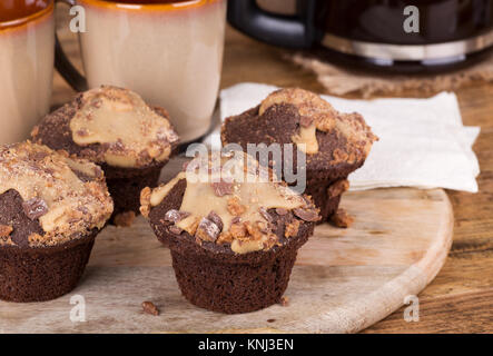 Peanut Butter Chocolate Cupcakes mit Zuckerglasur und Chips Stockfoto
