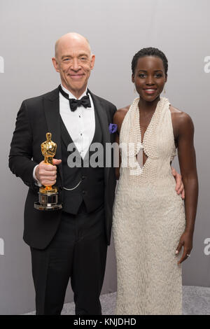 HOLLYWOOD, CA - 22. Februar: J.K. Simmons wirft Backstage mit Moderatorin und Schauspielerin Lupita Nyong'o, nach dem Gewinn der Oscar® für die Leistung durch einen Schauspieler in einer unterstützenden Rolle, für die Arbeit an "Schleudertrauma" während der Live ABC Telecast der 87 Oscars® auf der Dolby® Theater in Hollywood, CA am Sonntag, den 22. Februar, 2015. Stockfoto