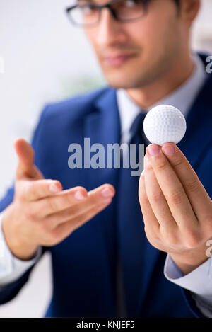 Junge Unternehmer mit Golf ball Arbeiten im Büro Stockfoto