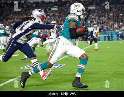 Miami Gardens, Florida, USA. 11 Dez, 2017. Miami Dolphins wide receiver DeVante Parker (11) ist durch die New England Patriots Cornerback Stephon Gilmore jagte (24) im ersten Quartal in der ersten Hälfte des Spiel zwischen den New England Patriots und die Miami Dolphins im Hard Rock Stadion in Miami Gardens, Fla., am Montag, den 11. Dezember 2017. Quelle: Andres Leiva/der Palm Beach Post/ZUMA Draht/Alamy leben Nachrichten Stockfoto