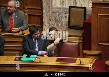 Athen, Griechenland. 12 Dez, 2017. Mitglieder des Syriza Bundeskabinett in das griechische Parlament. Auf der Rückseite ist Terence Schnelle, stellvertretender Staatsminister für die Koordination der Regierung. Vorne, auf der linken Seite, ist George Chouliarakis, Stellvertretender Minister der Finanzen. Am ersten Tag der Haushaltsdebatte im griechischen Parlament. Die Regierung von Syriza und Anel vorhanden, was sie als die "letzte, welche in Zeiten der Vereinbarung zu fördern". Credit: Ioannis Mantas/Alamy leben Nachrichten Stockfoto